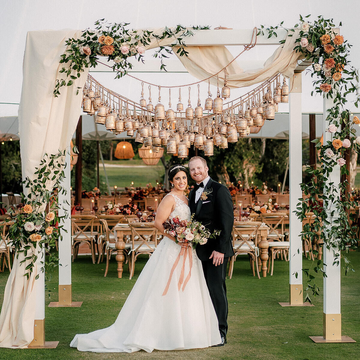 Wedding couple posing under the structured entrance to their earth-tone wedding reception at the Park Hyatt Aviara.