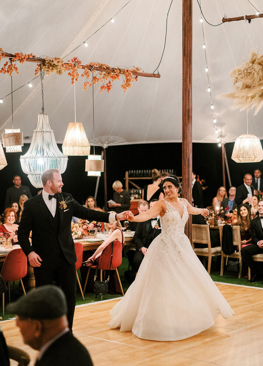 A groom twirls his bride at their earth tone wedding reception in California.