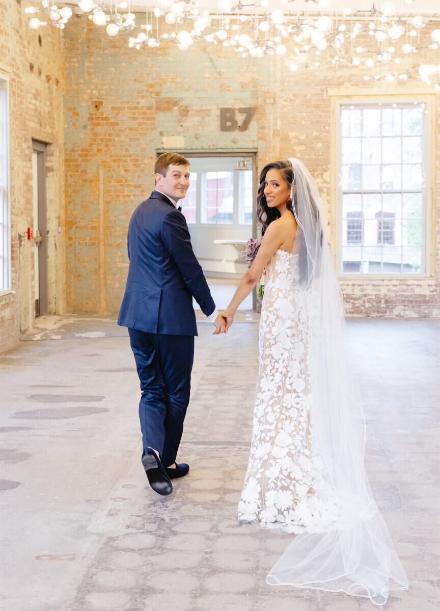 A pair of newlyweds walk through one of the industrial event spaces used for their art museum wedding.