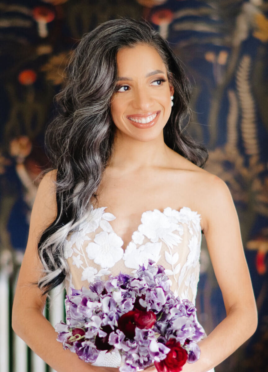 For her art museum wedding, a bride went with loose waves and a side part that showed off her Oscar de la Renta strapless wedding dress.