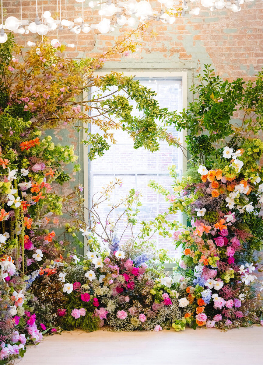 One corner of an industrial event space was covered with flowers and greenery to provide the backdrop for an art museum wedding ceremony.