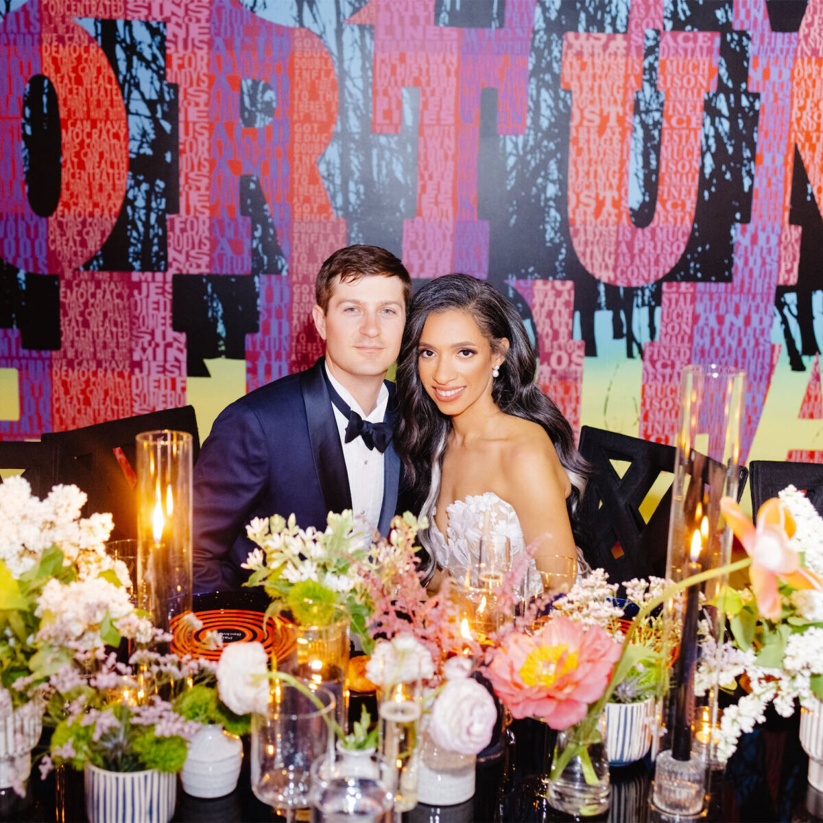 A groom and bride sit at the singular reception table at their art museum wedding at MASS MoCa.