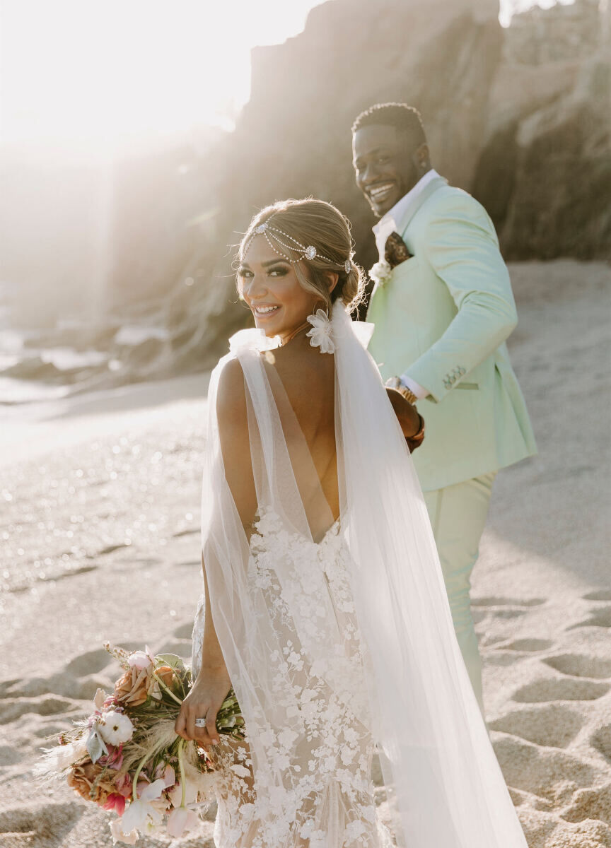 Wedding couple walking hand in hand along the beach