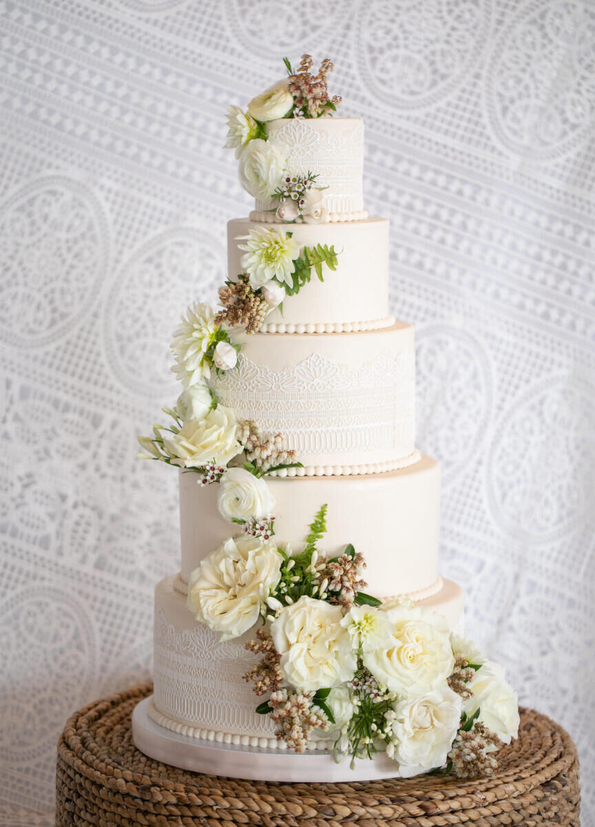 Neutral white wedding cake adorned with cascading flowers