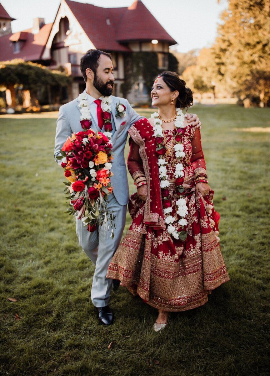 Castle Wedding Venues: A wedding couple smiling while walking away from a castle wedding venue that also functions as a marina in Connecticut.