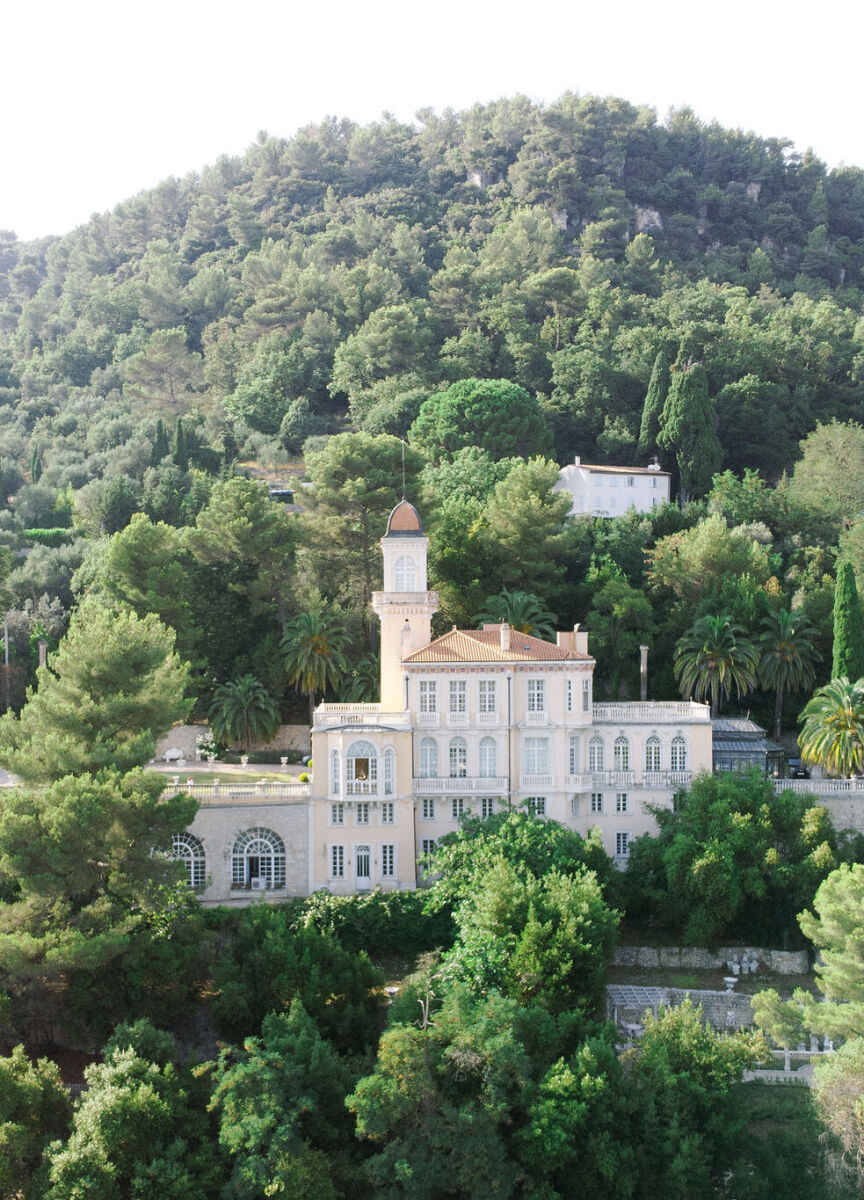 Castle Wedding Venues: A chateau tucked away on a hillside in France, completely surrounded by trees.