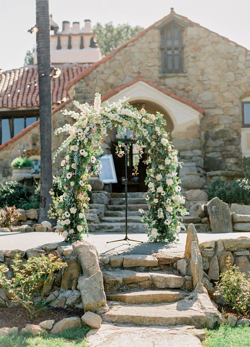 Castle Wedding Venues: An outdoor ceremony arch positioned on the patio at a stone and Spanish-style castle property in Southern California.