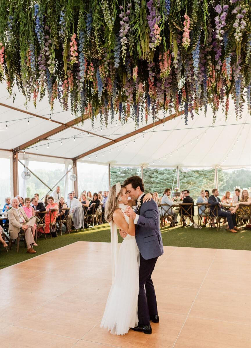 Ceiling Wedding Decor: Multicolored florals hanging down above a wedding couple dancing below.