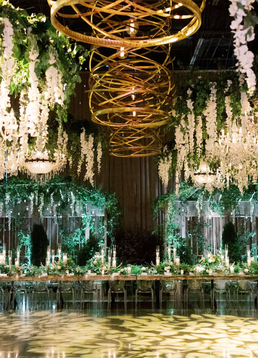 Ceiling Wedding Decor: Hanging white flowers all over the ceiling of a reception space with wooden light fixtures in the center.