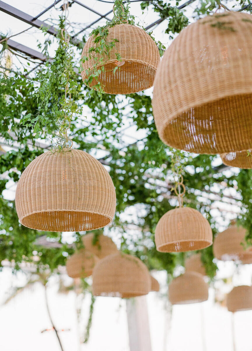 Ceiling Wedding Decor: Bell-shaped rattan light fixtures with greenery.