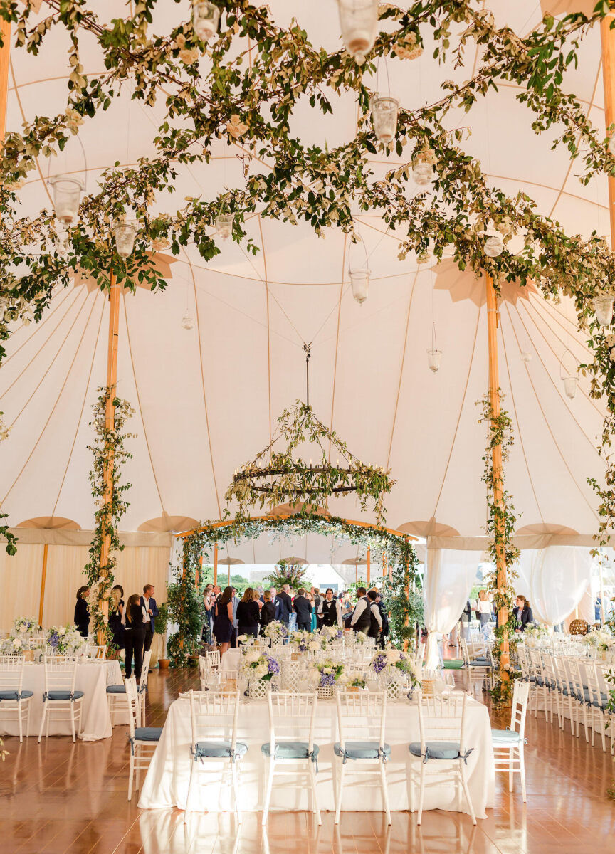 Ceiling Wedding Decor: Greenery strung across the ceiling of a white tent at a wedding.