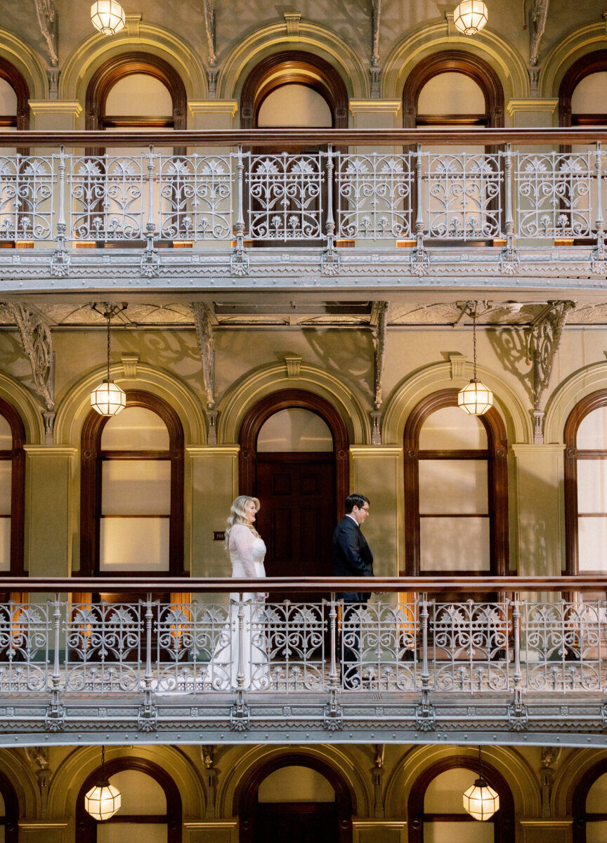 City Weddings: A bride approaching a groom on an indoor balcony at Manhatta in downtown New York City.