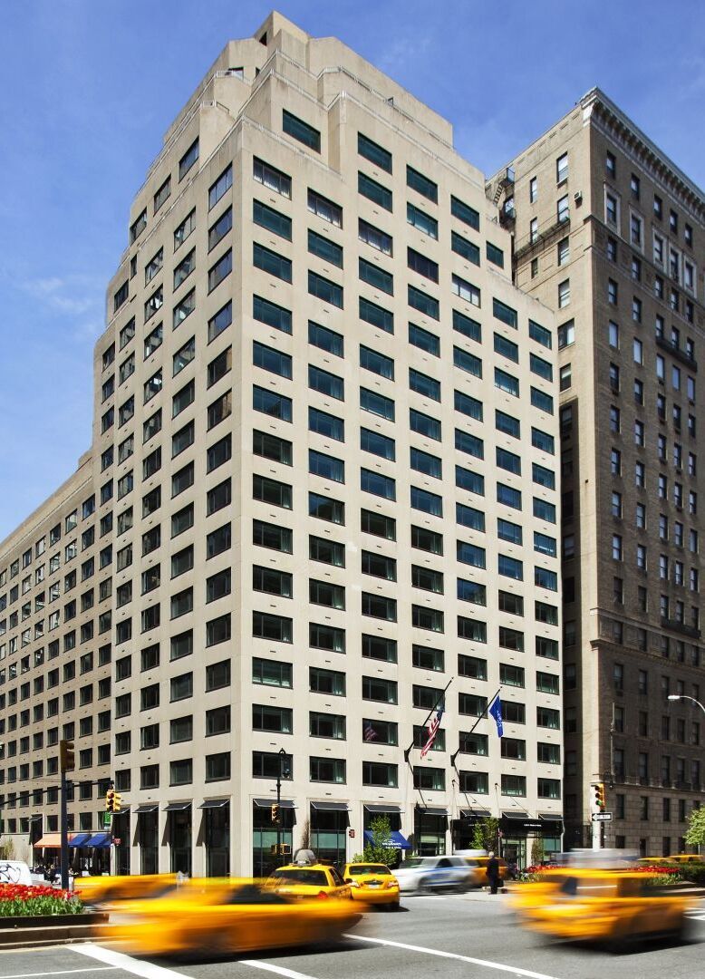 City Weddings: A street view of the Loews Regency New York Hotel, with taxis driving by.