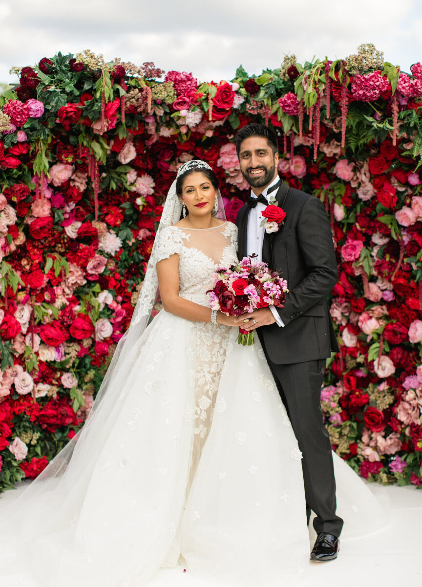 A bride and groom right after their colorful countryside wedding ceremony, which was designed in shades of pink and red.