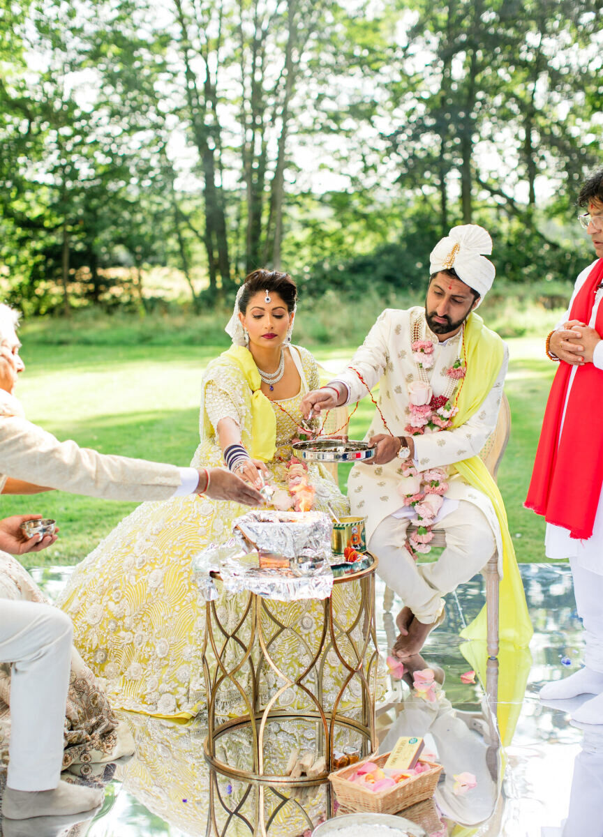 A bride and groom during their colorful countryside wedding ceremony.