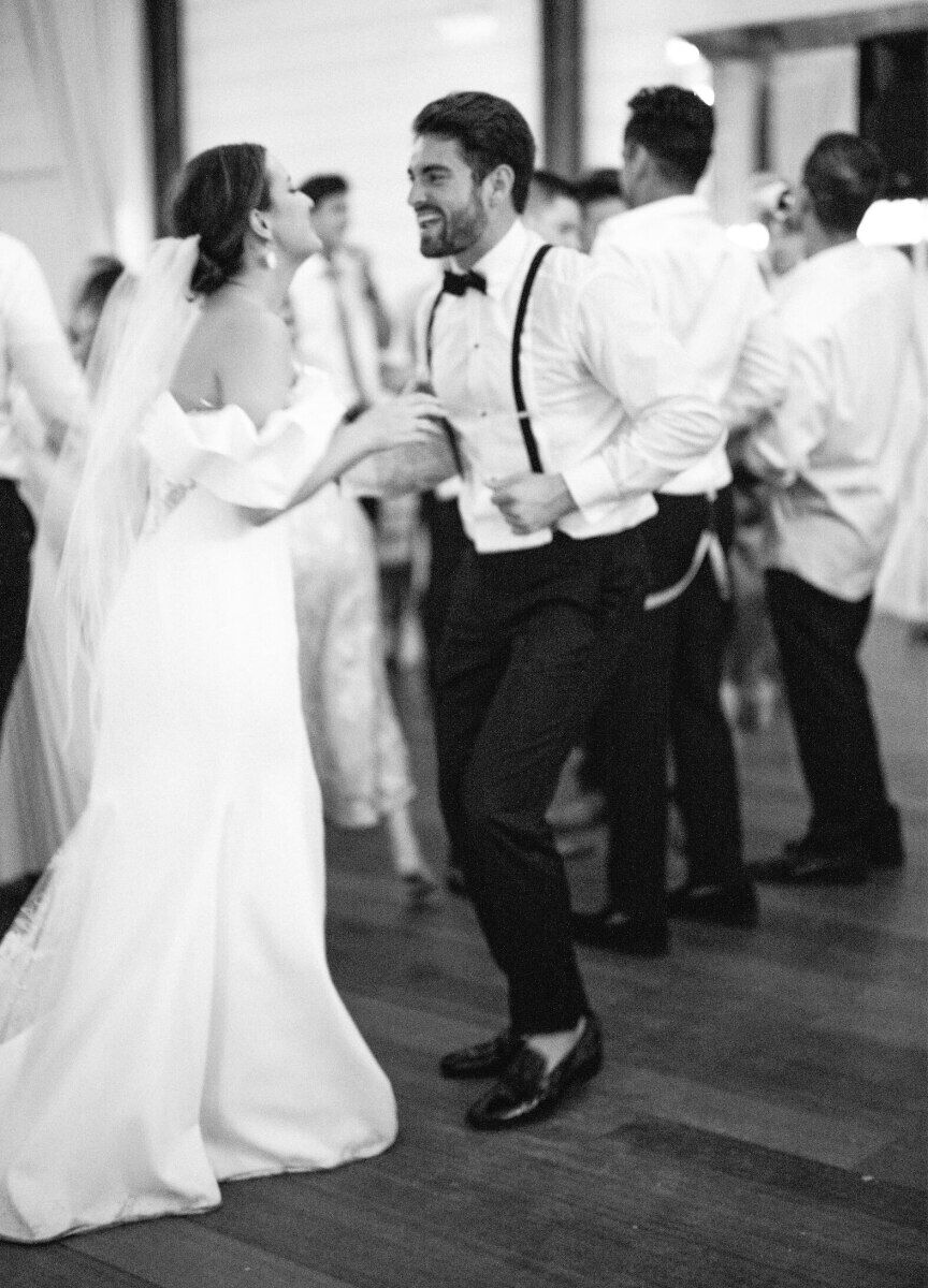 A couple and their guests dance while a DJ plays music at their Pippin Hill Farm & Vineyards wedding.