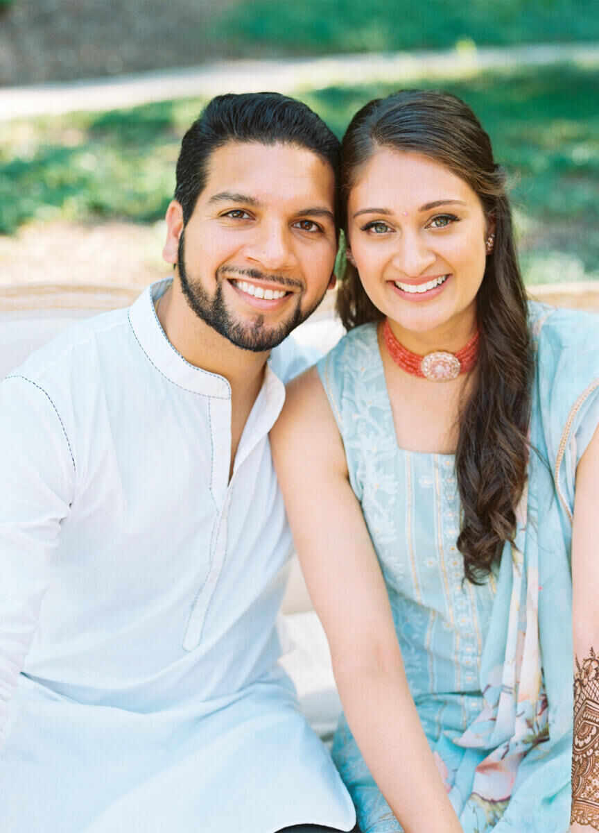 A groom and bride smile for the camera at their mehndi during their destination Indian wedding weekend in Raleigh.