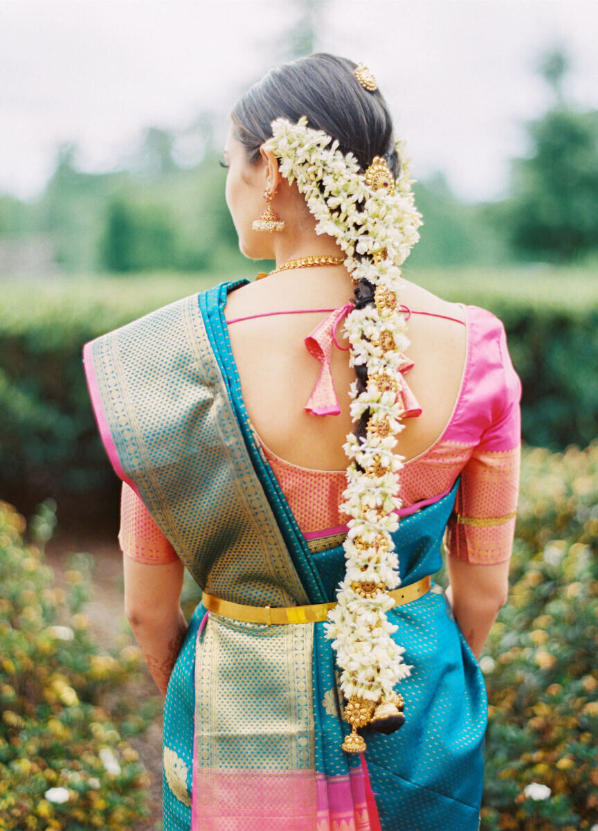 A bride with an ornate hairstyle covered in fresh flowers during her destination Indian wedding weekend, which included an engagement celebration.