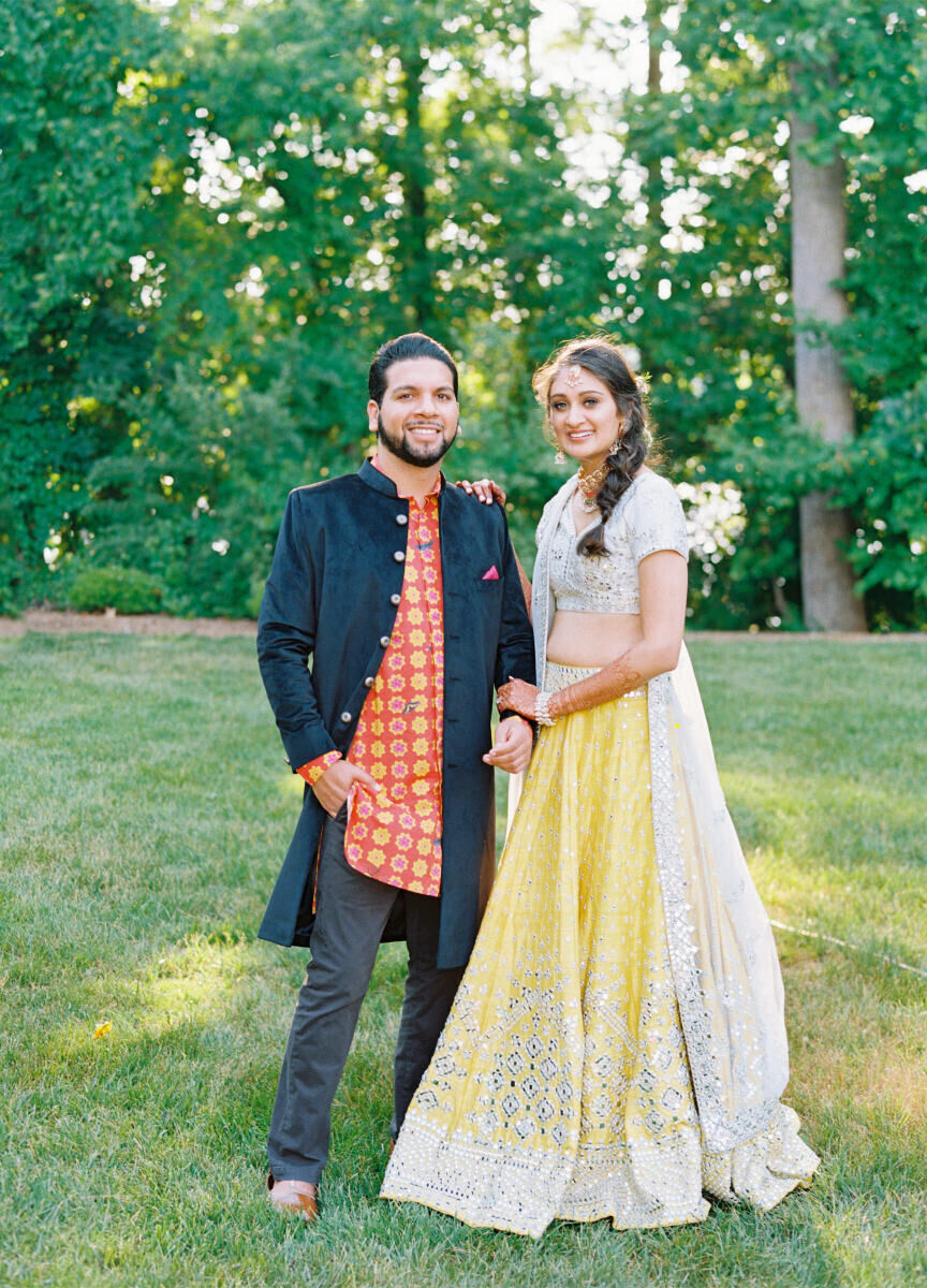 A groom and bride pause for a portrait on the lawn of the hotel where the sangeet took place during their destination Indian wedding weekend.