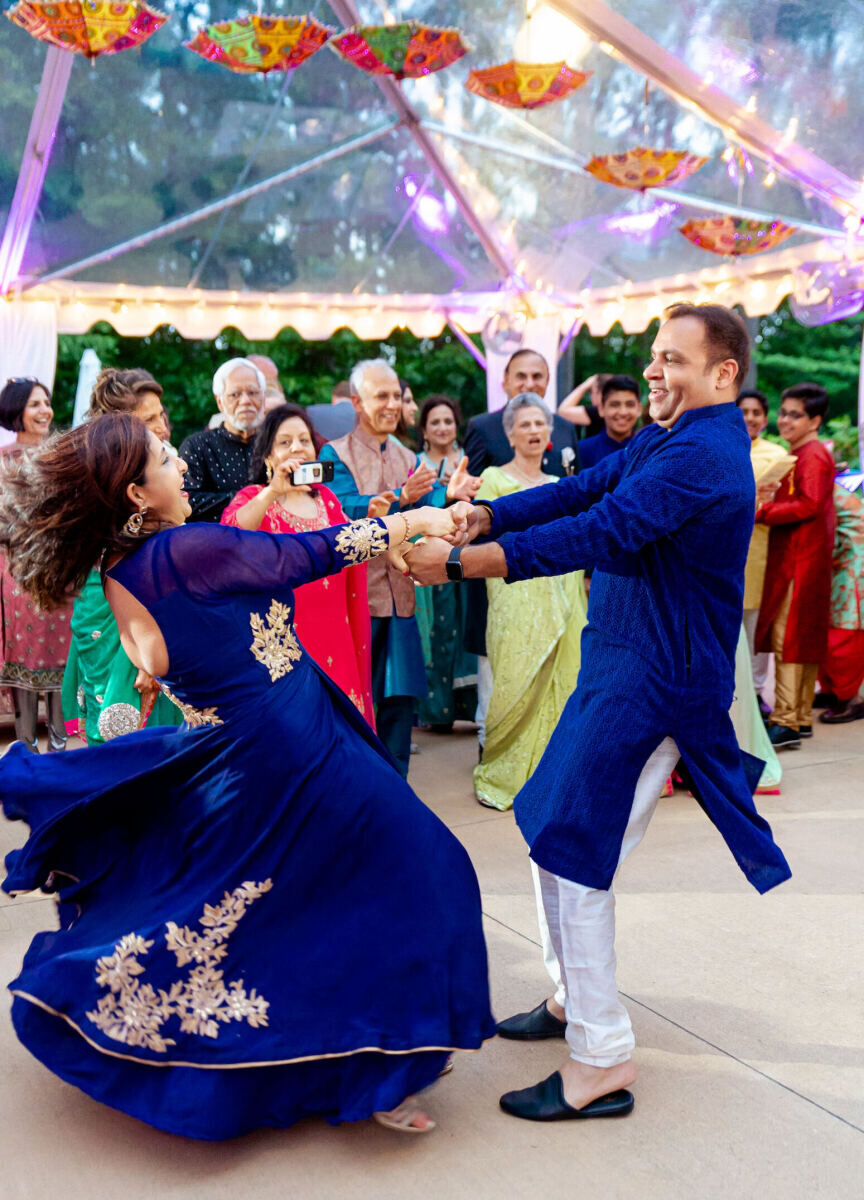 Guests dance under a clear tent at a destination Indian wedding's sangeet.