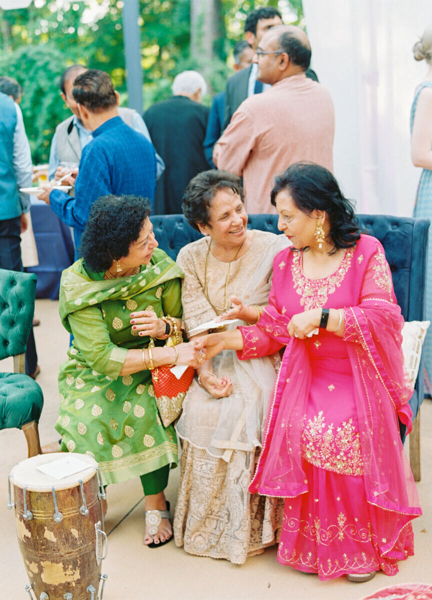 A trio of guests mingle at a destination Indian wedding.