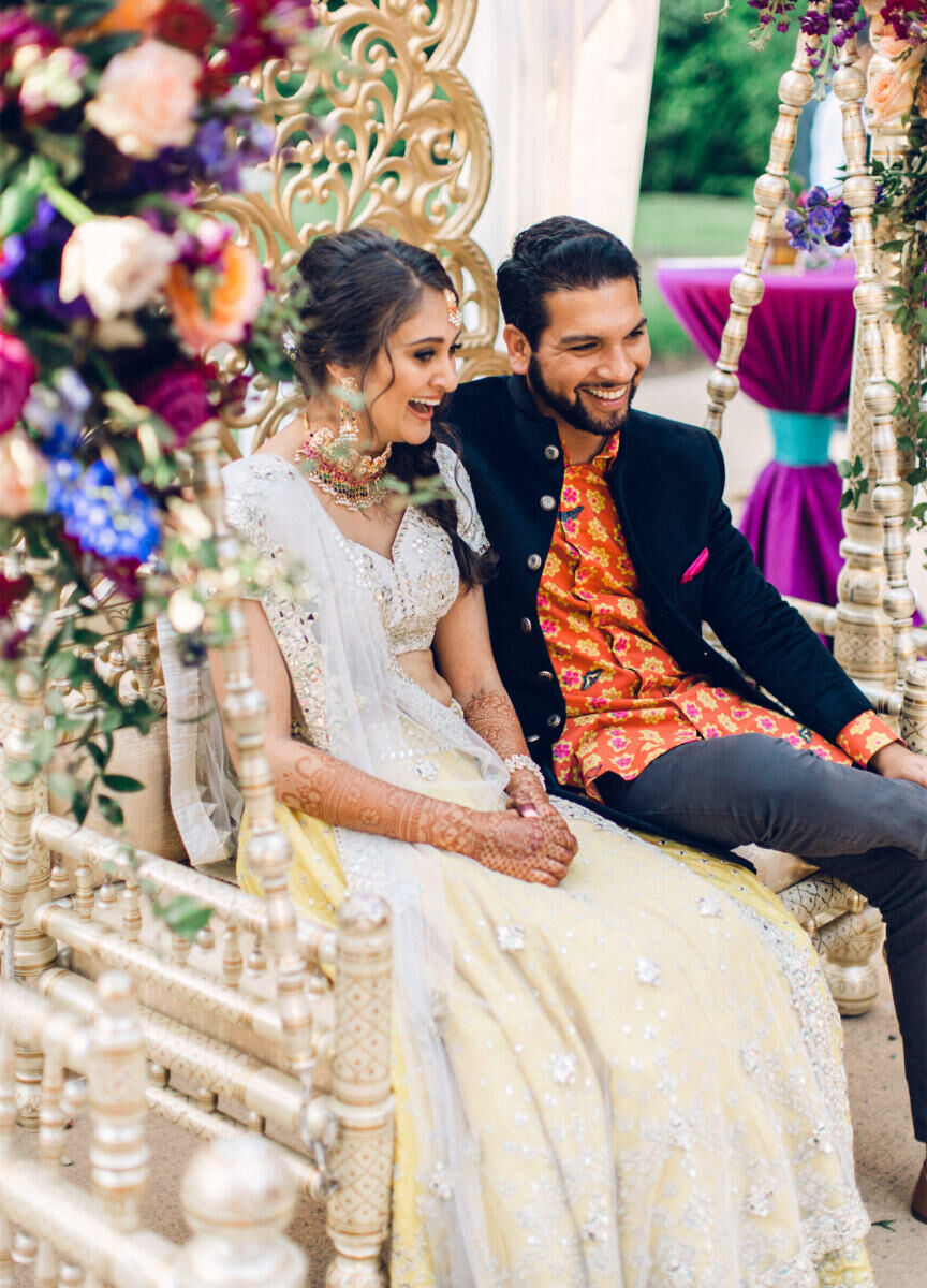 A bride and groom have a laugh at the sangeet during their destination Indian wedding weekend.