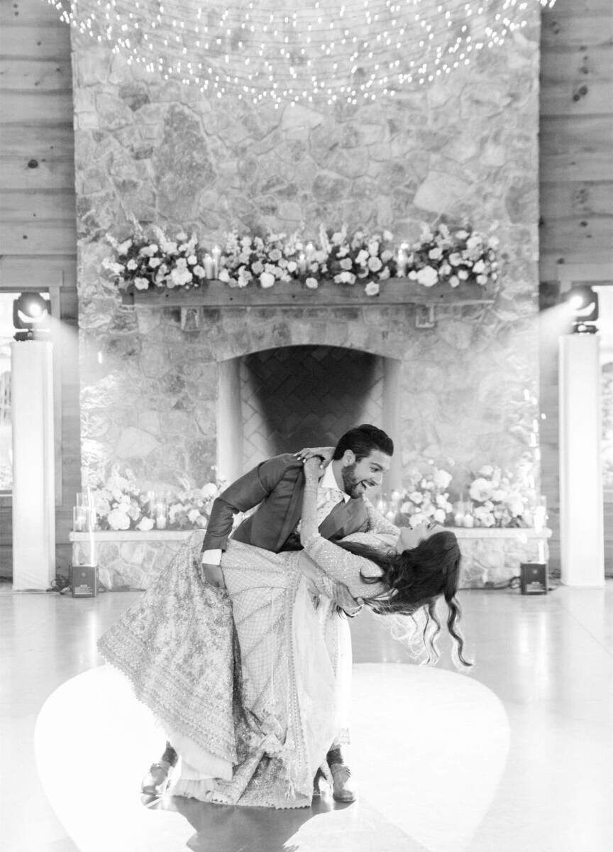 A groom dips his bride during their first dance—one of many choreographed numbers during their multi-day destination Indian wedding.