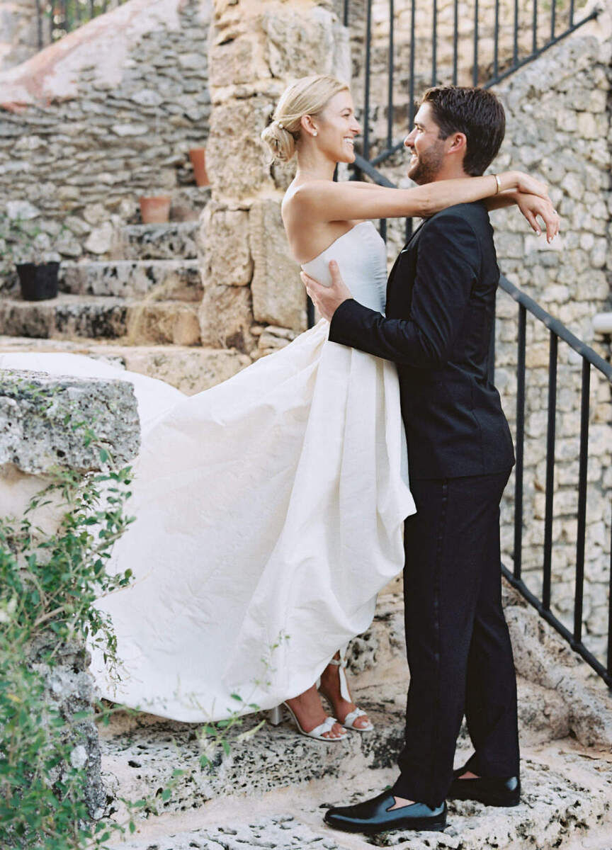 A bride and groom look into each others eyes and smile while taking portraits during their destination wedding in the Dominican Republic.