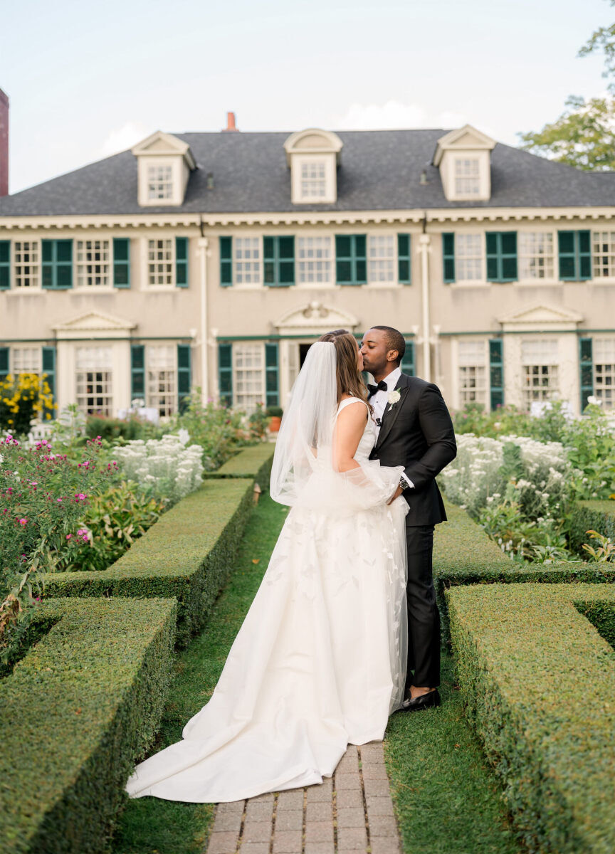 A bride kisses her groom in the gardens of Hildene, following their elevated garden wedding ceremony.