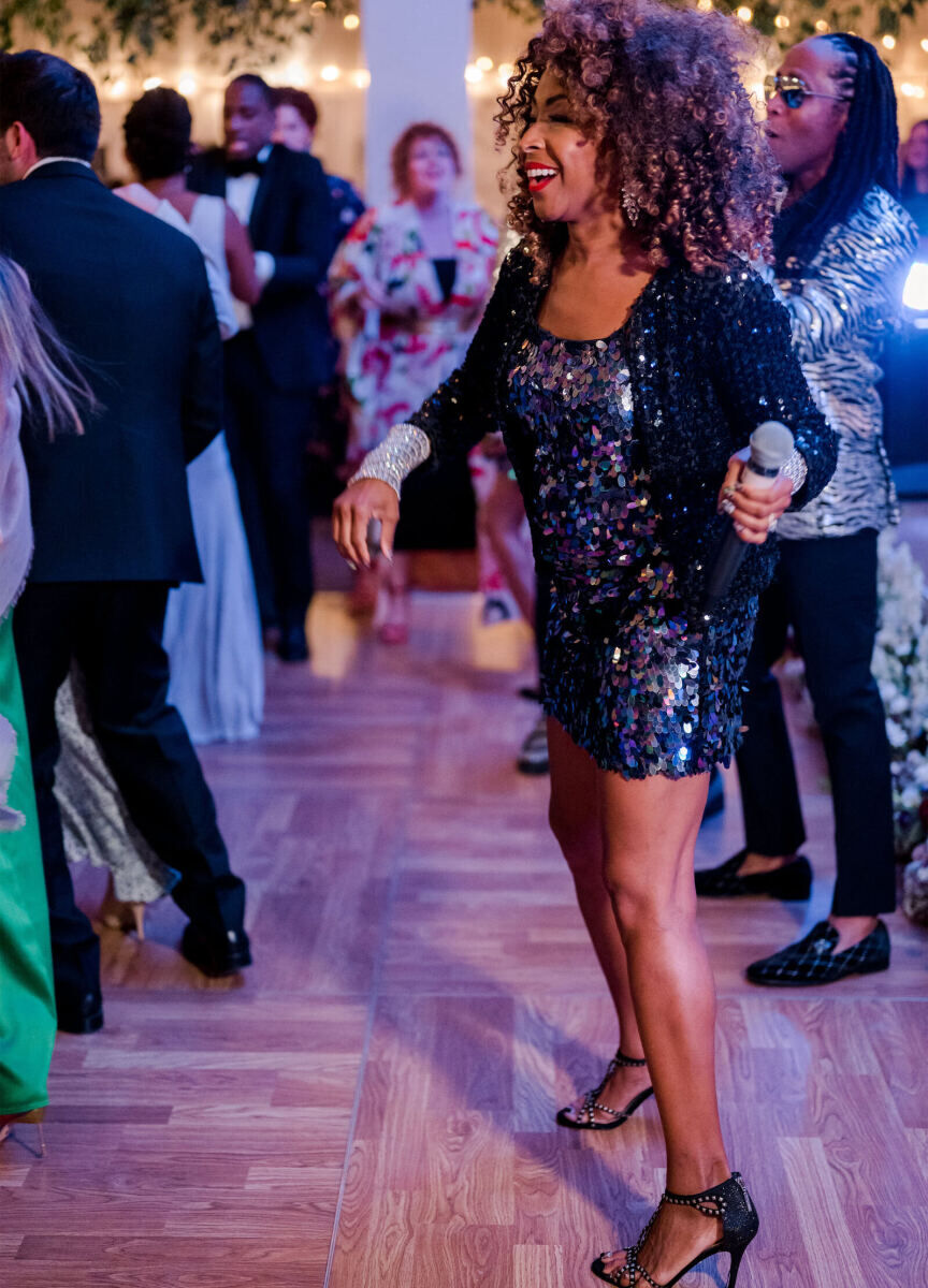 A member of the band takes to the dance floor during an elevated garden wedding reception.