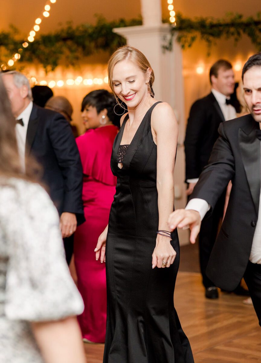 Guests dance inside the tent of an elevated garden wedding reception.