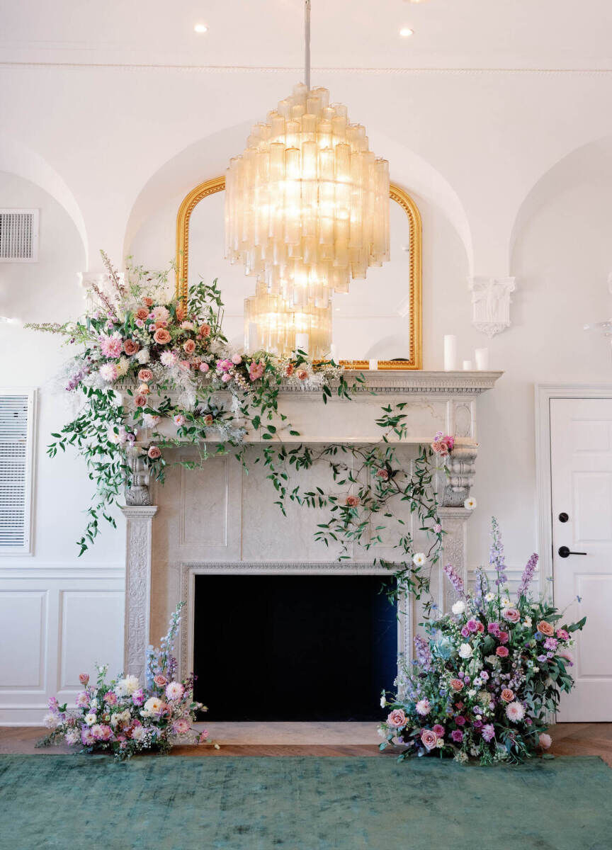 The fireplace in the suite of the Riggs Hotel, decorated with asymmetrical flowers for the setting of an elopement wedding.