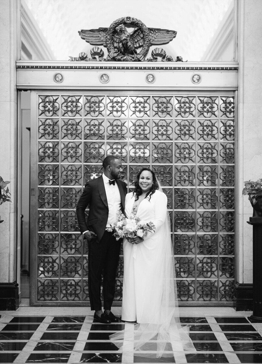 A couple pose inside the Riggs Hotel on the day of their elopement wedding.