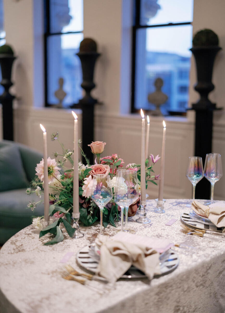 Elopement Wedding: Iridescent glassware set next to an eclectic place setting by candles and and floral arrangement.