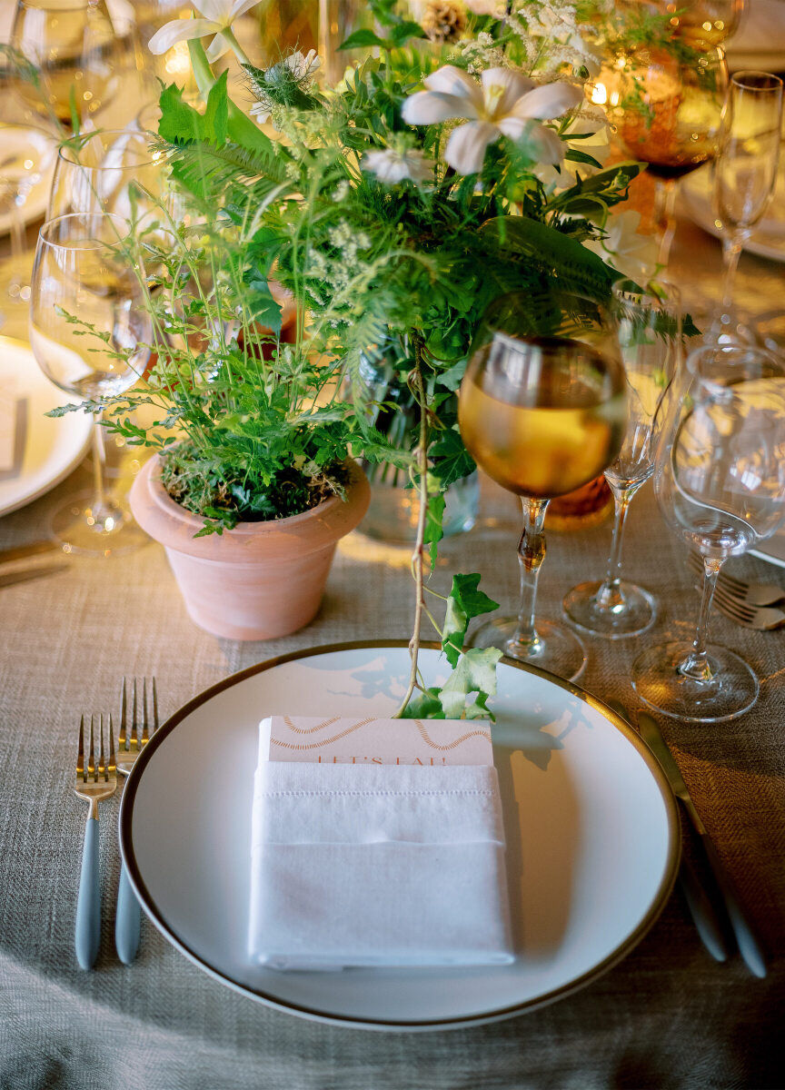 Greenery and herbs took center stage on each of the oval tables at this enchanted waterfront wedding.