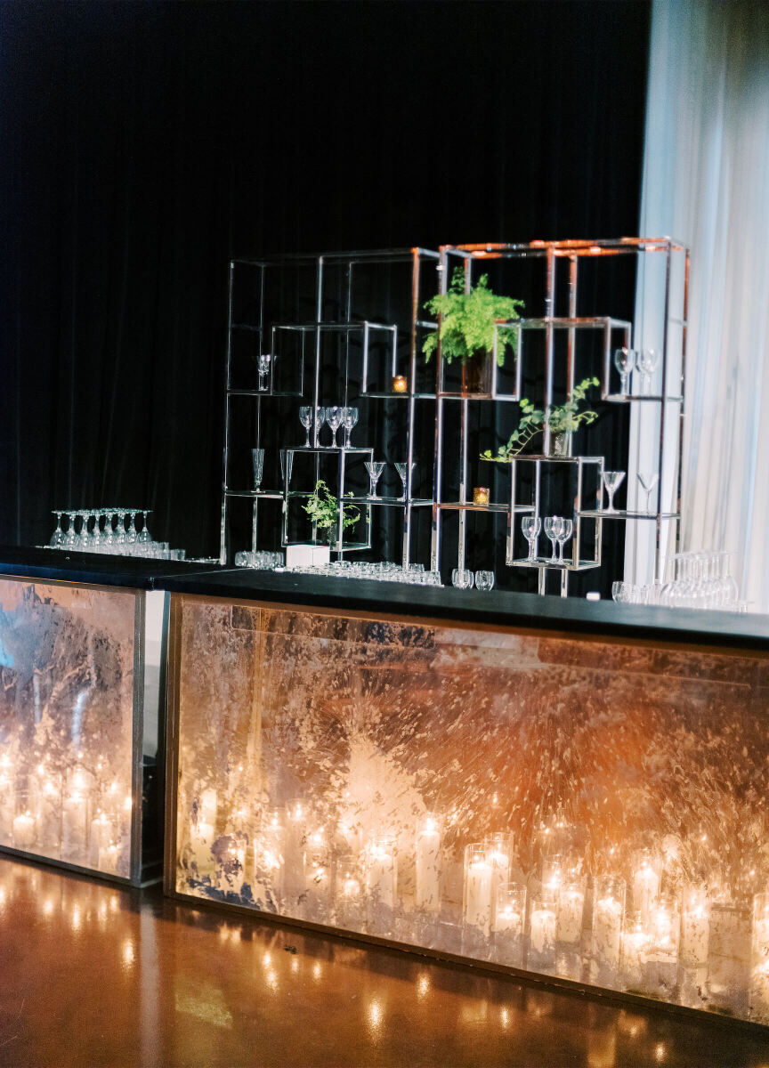 Candles illuminated a translucent bar from within at an enchanted waterfront wedding reception in Chicago.