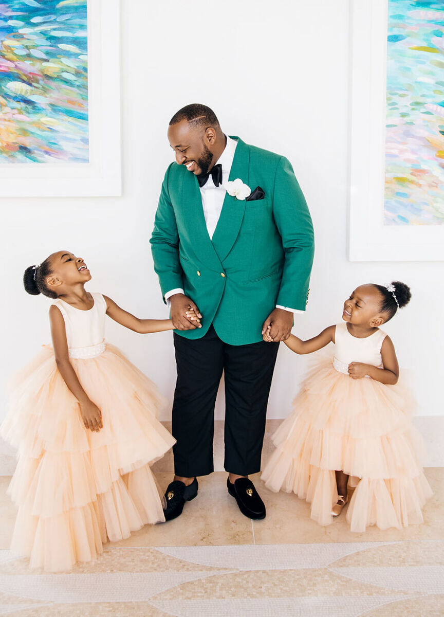 First Look Photos: A groom smiling in a portrait with his two daughters.