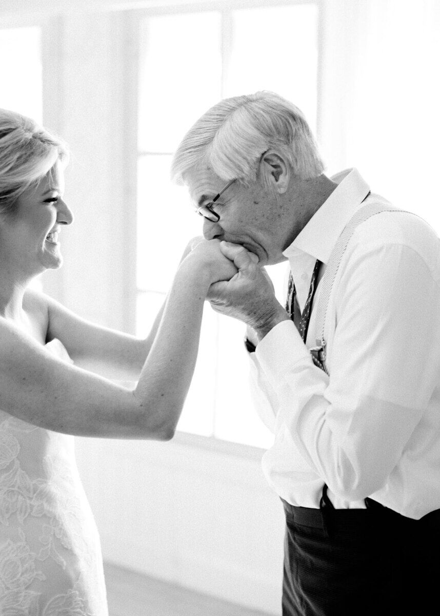 First Look Photos: A father kisses his daughter's hands on her wedding day.