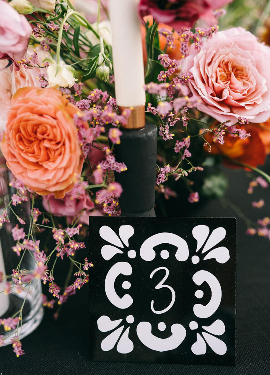 Black and white tile table numbers guided guests to their seats at a glam beach wedding in Cabo.