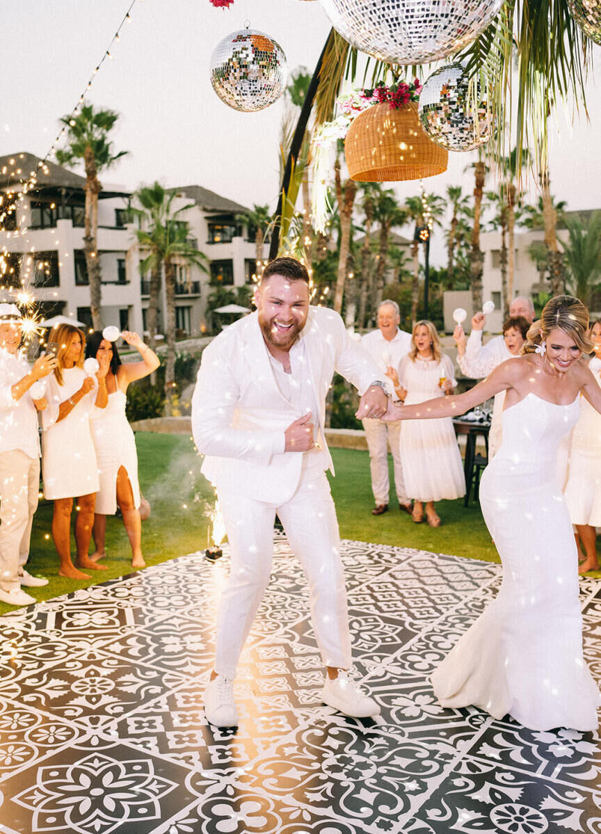 A groom and bride arrive at their glam beach wedding reception and immediately hit the faux-tiled dance floor.