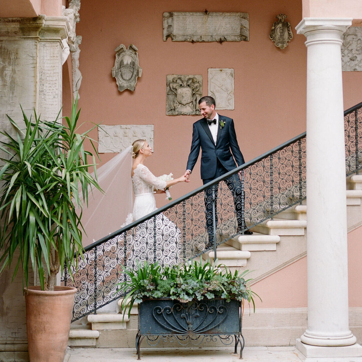 A bride and groom ascend a staircase at their Glenmere Mansion wedding.