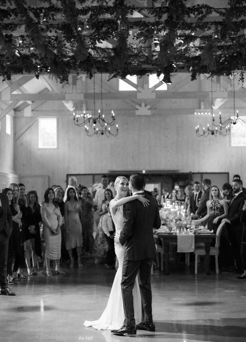 Newlyweds share a first dance under a lattice of greenery at their Glenmere Mansion wedding reception.