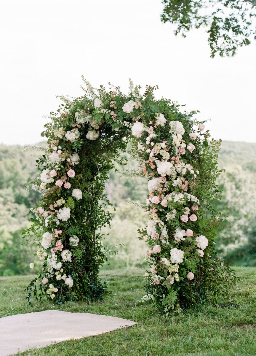 For a Glenmere Mansion wedding, Stonekelly Events created a ceremony arch with a base of greenery and further decorated with an array of pale pink and white flowers.