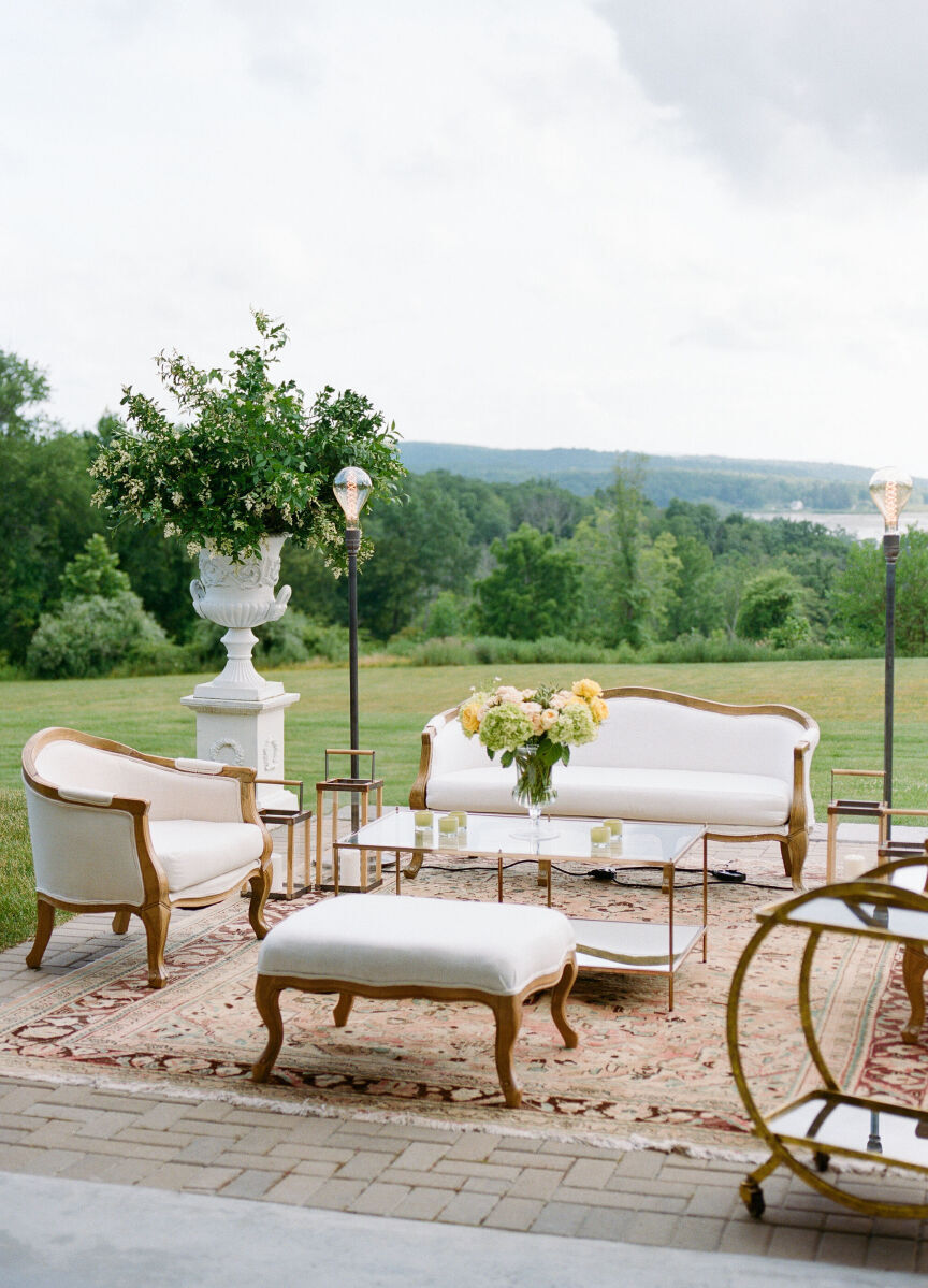 Crisp white lounge furniture setup at a Glenmere Mansion wedding, on the terrace overlooking the lawn.