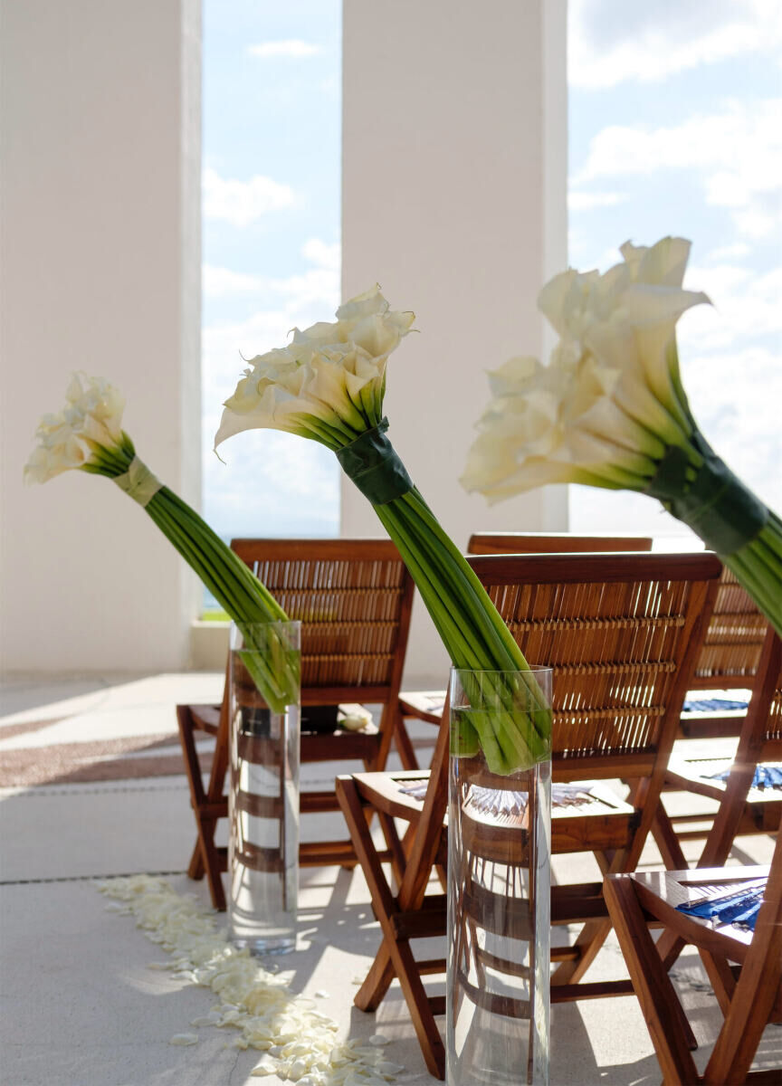 Grand Velas Riviera Nayarit: Long-stemmed floral arrangements next to rows of wooden chairs.