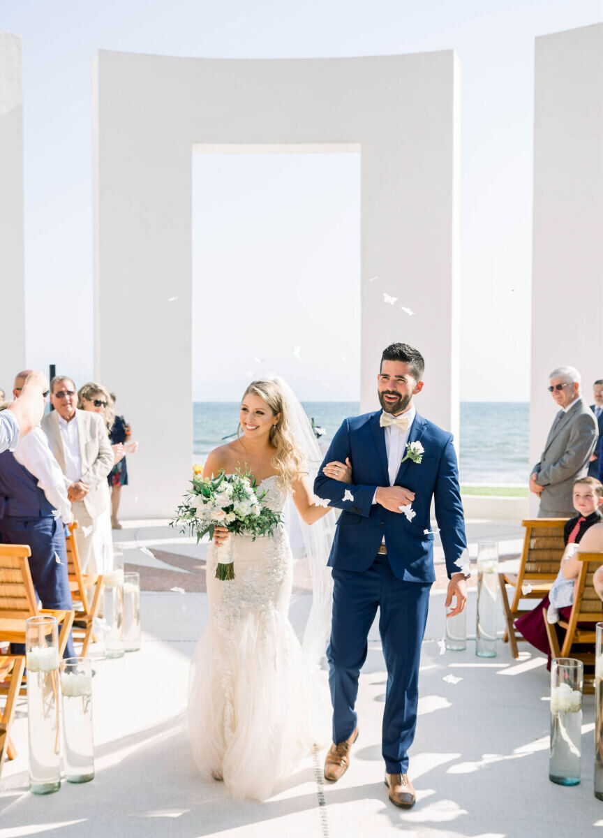 Grand Velas Riviera Nayarit: A bride and groom exiting a modern gazebo after their wedding ceremony.