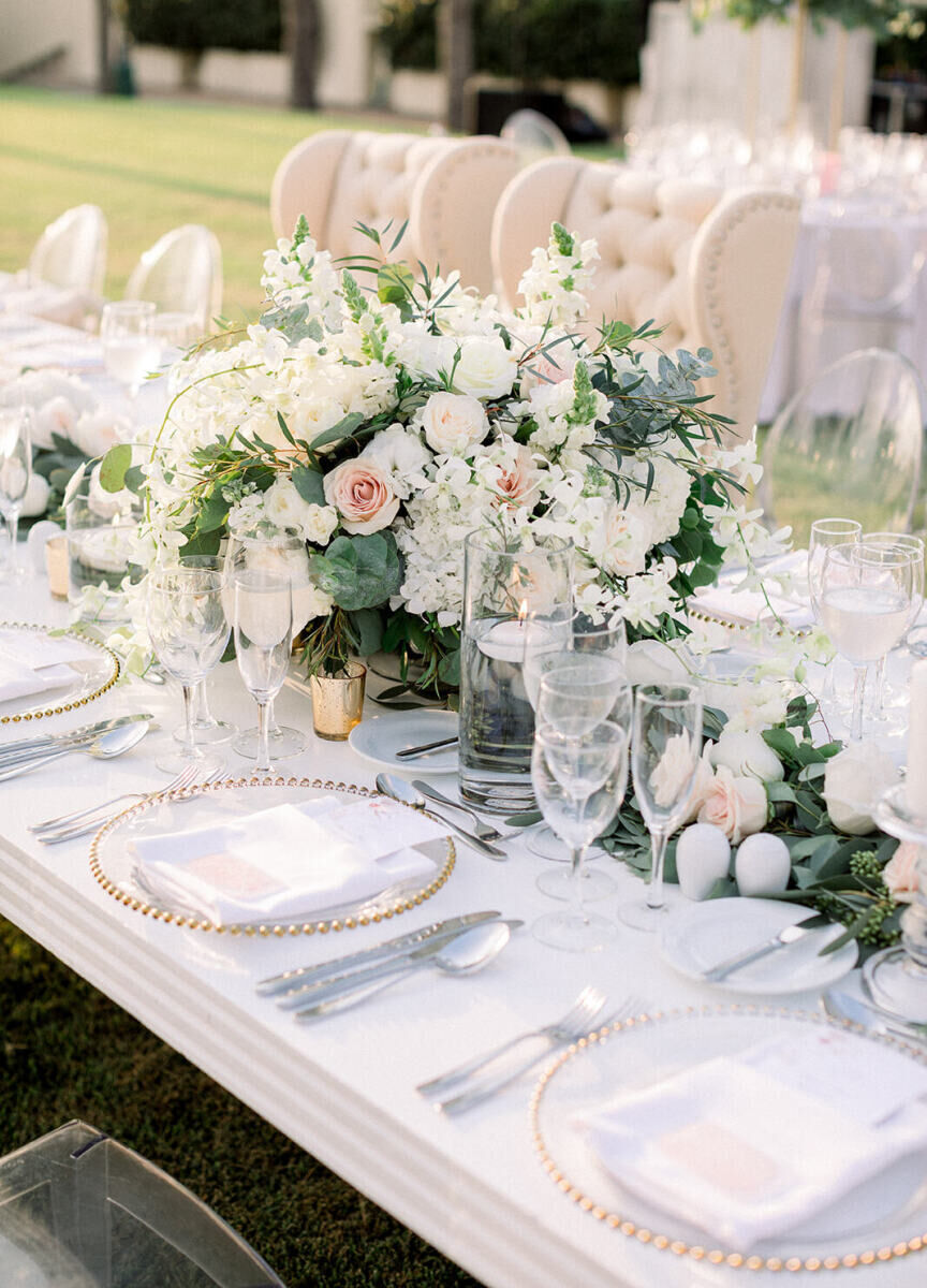 Grand Velas Riviera Nayarit: A tablescape with two white chairs, several acrylic chairs, and a large white floral arrangement.