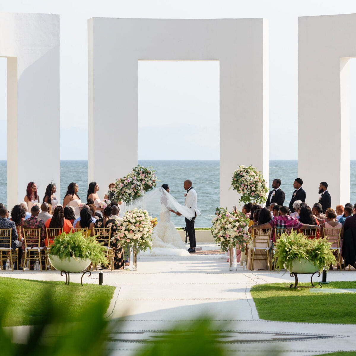 Grand Velas Riviera Nayarit: A bride and groom exchange vows at a modern white gazebo in Mexico.