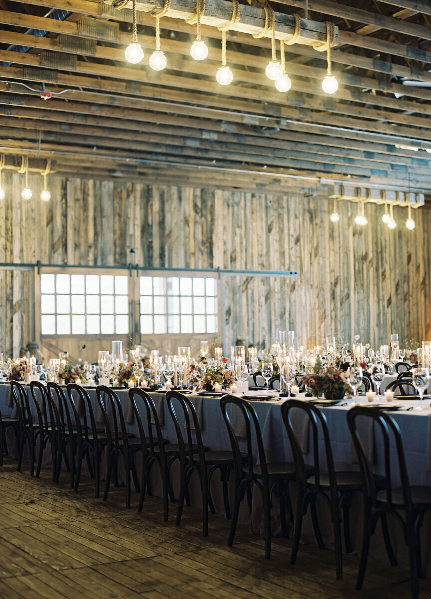 Holiday Wedding: A reception set-up in a wood-paneled room with dark tablecloths and chairs.