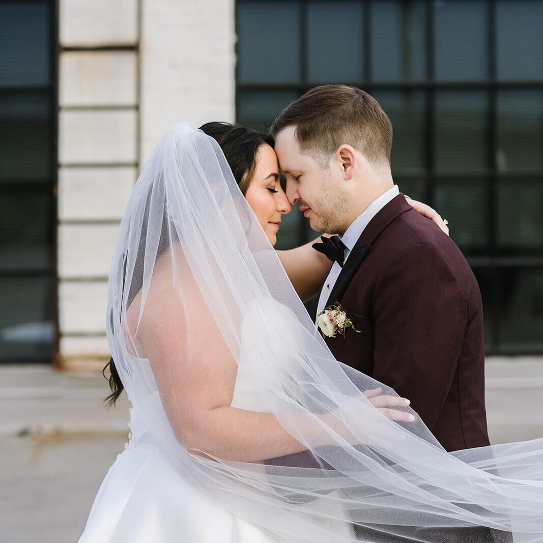 A bride and groom embrace on a street in Baltimore, where their industrial wedding took place.